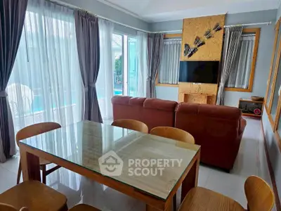 Spacious living room with pool view, elegant dining area, and modern decor.