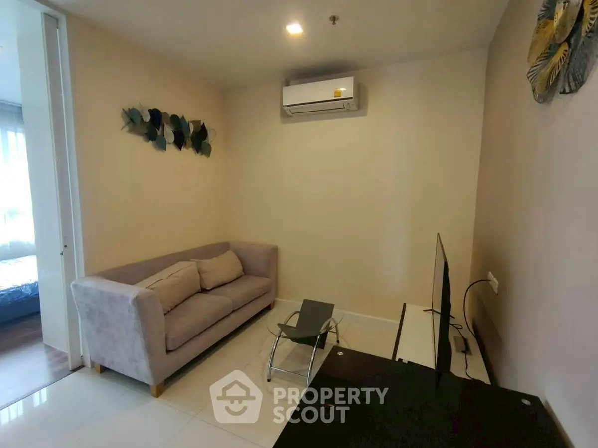 Cozy living room with modern decor and air conditioning, perfect for relaxation.