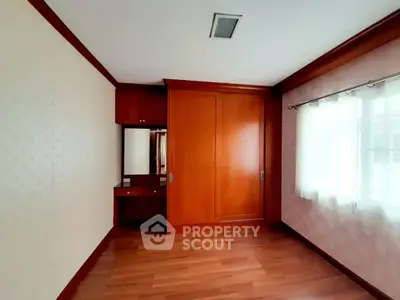 Spacious bedroom with wooden flooring and built-in wardrobe