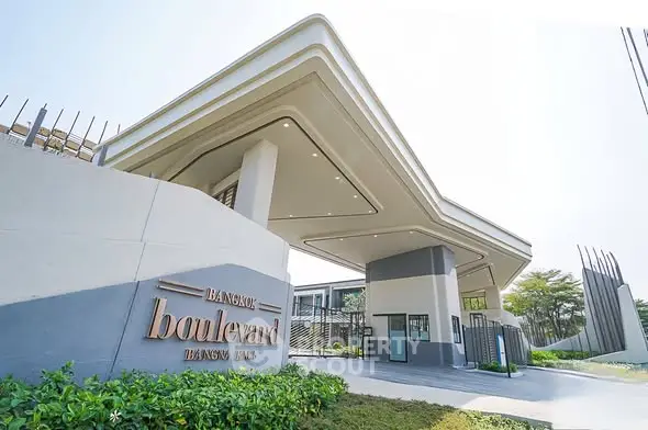 Modern luxury residential entrance with sleek architectural design and lush greenery.