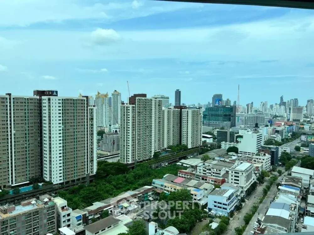 Stunning cityscape view from a high-rise building showcasing urban skyline and lush greenery.