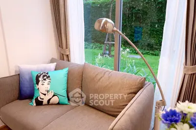 Cozy living room with stylish sofa and garden view, perfect for relaxation.