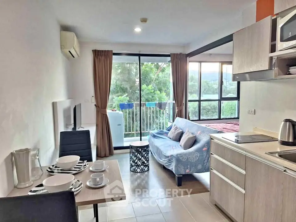 Modern open-plan living room with kitchen and balcony view