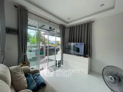 Cozy living room with modern decor and large window overlooking outdoor area.