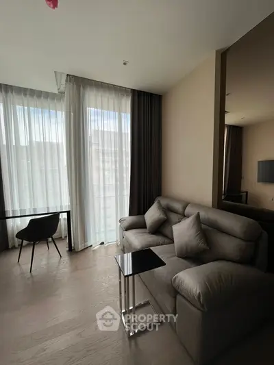 Modern living room with sleek furniture and large windows for natural light.