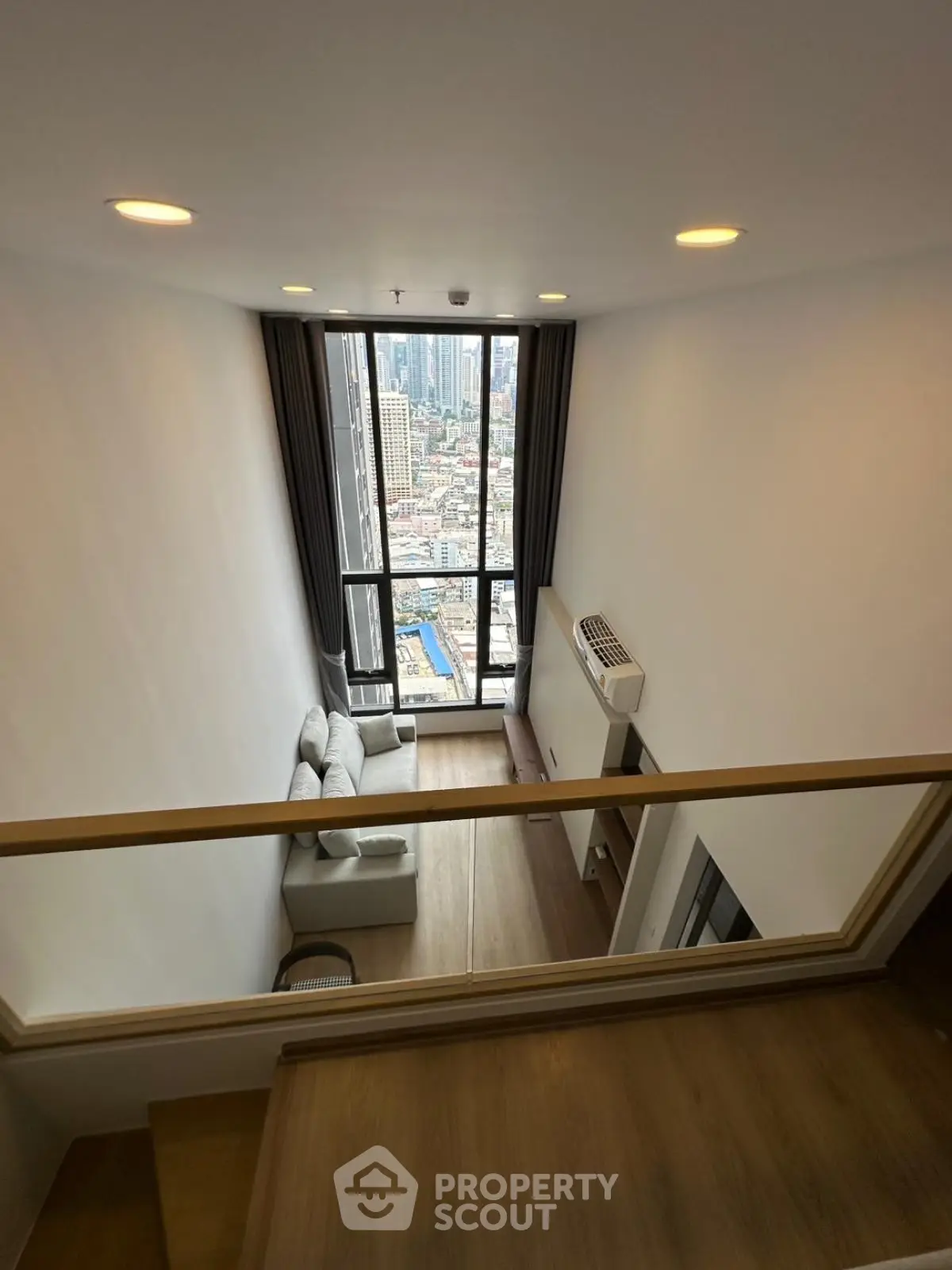 Stunning loft-style living room with floor-to-ceiling windows offering breathtaking city views.
