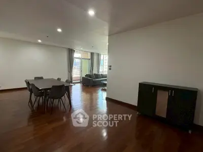 Spacious open-plan living and dining area with modern furnishings and large windows.
