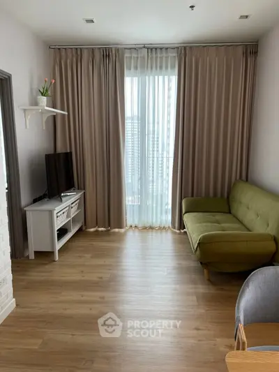 Modern living room with green sofa and large window view