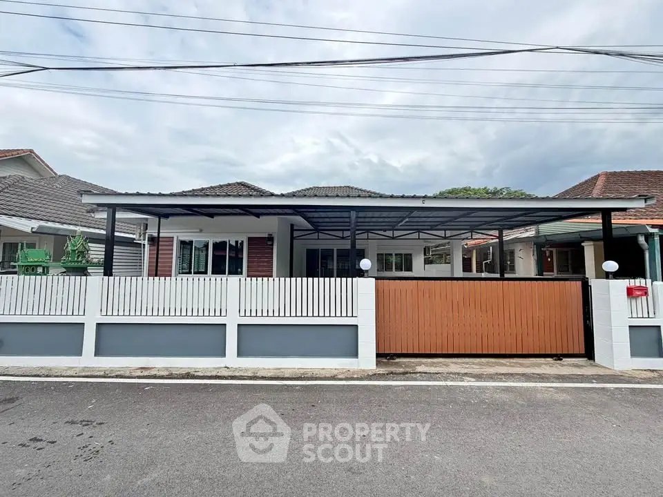 Charming single-story house with modern fence and spacious driveway in a serene neighborhood.