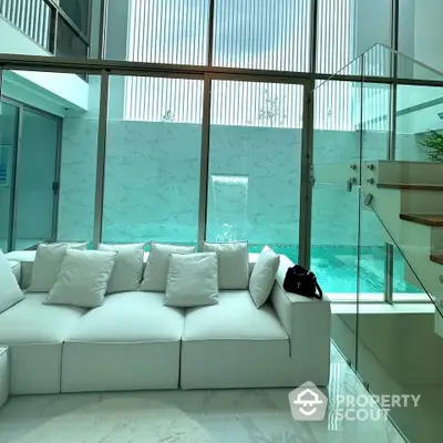 Luxurious modern living room with pool view and elegant white sofa