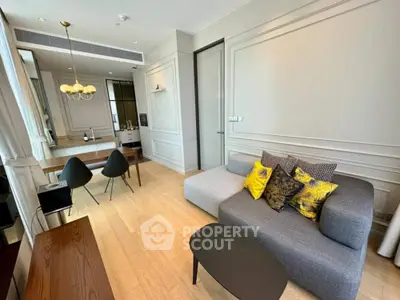 Modern living room with stylish decor and dining area, featuring elegant lighting and cozy seating.