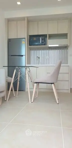 Modern kitchen with sleek appliances and dining area in open layout.