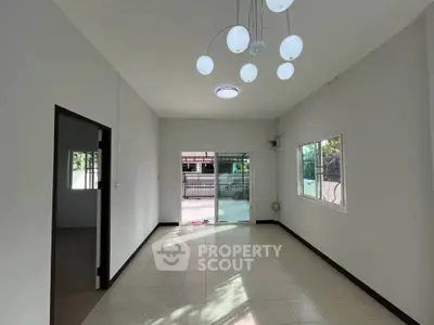 Spacious living room with modern lighting and large windows for natural light.
