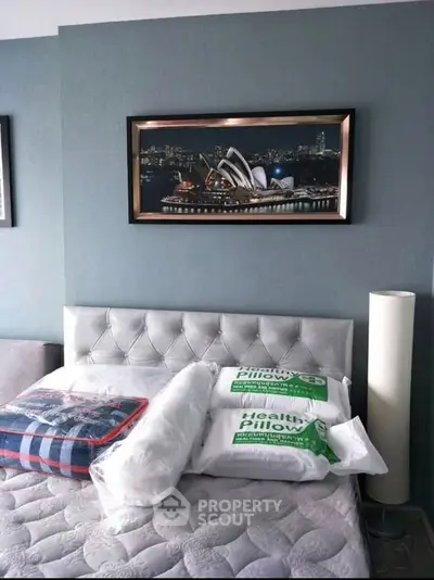 Stylish bedroom with elegant decor and modern artwork, featuring a plush bed and chic lighting.