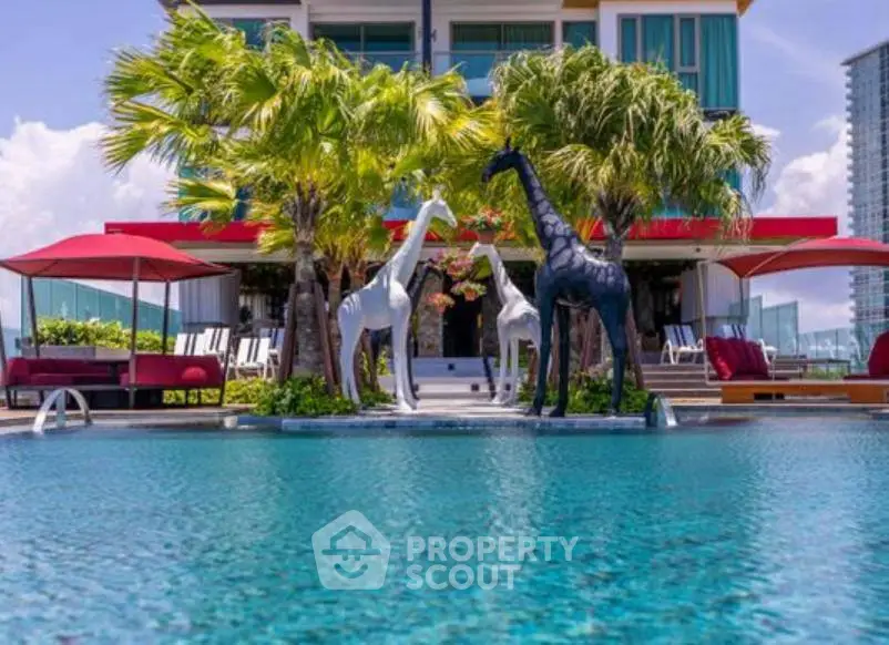 Luxurious poolside view with exotic sculptures and modern architecture, perfect for upscale living.