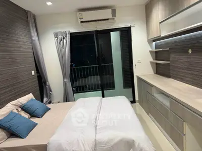 Modern bedroom with balcony view, featuring sleek cabinetry and air conditioning for ultimate comfort.