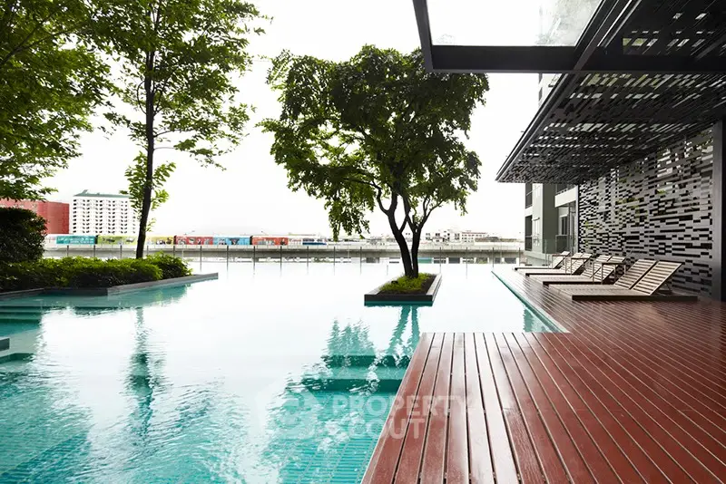 Luxurious modern poolside area with stylish deck and lush greenery, perfect for relaxation and leisure.
