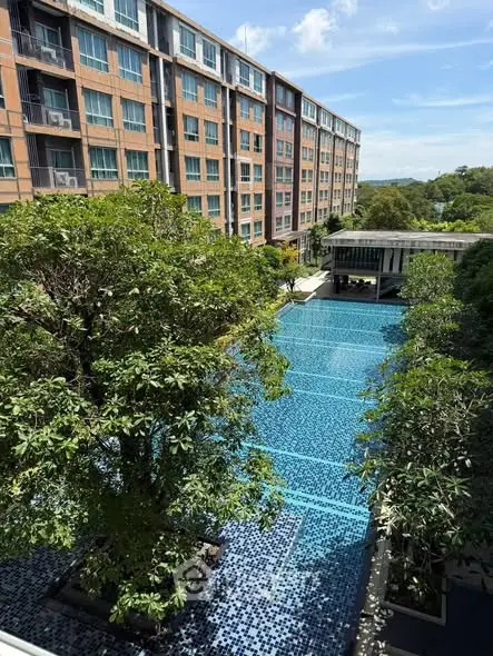 Luxurious residential building with stunning pool and lush greenery view.