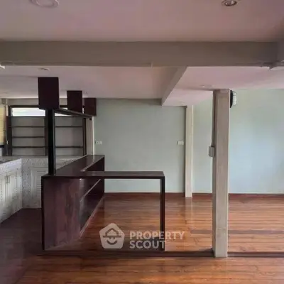 Spacious open-plan living area with wooden flooring and modern design elements.