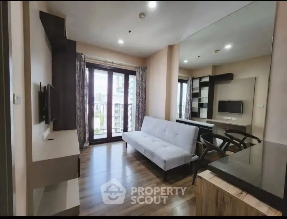 Modern living room with sleek furniture and large windows offering natural light.