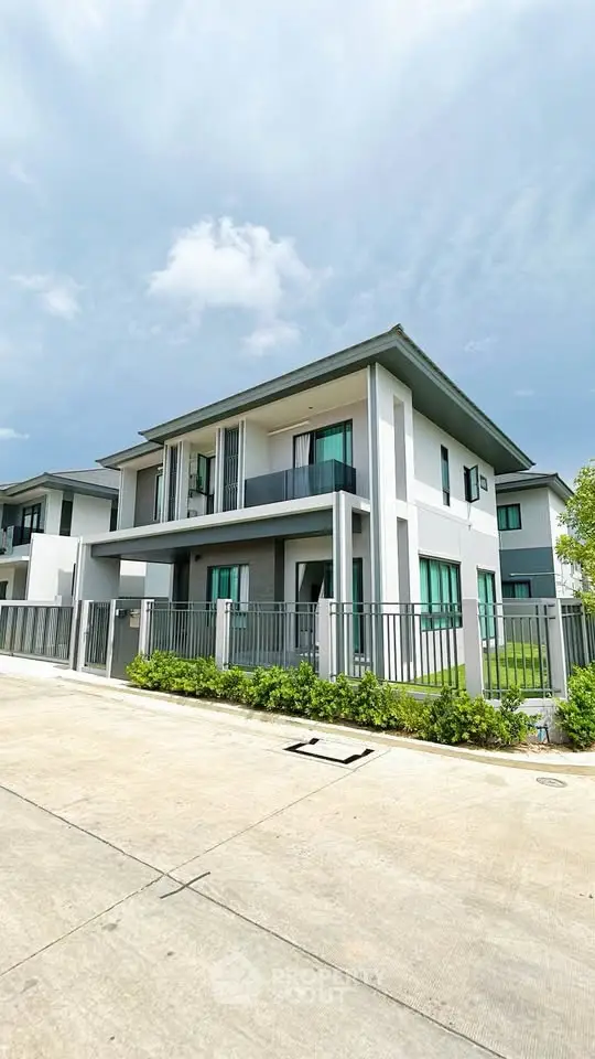 Modern two-story house with sleek design and spacious balcony in a serene neighborhood.
