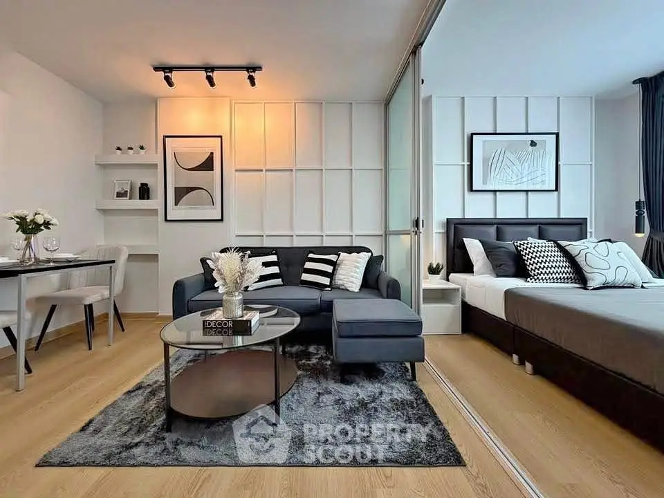 Modern studio apartment with stylish living area and cozy bedroom, featuring elegant decor and open layout.