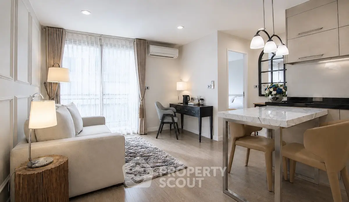Modern living room with elegant decor and open kitchen layout, featuring cozy seating and stylish lighting.