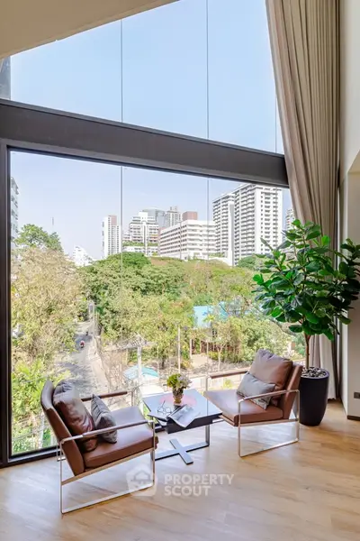 Luxurious living room with floor-to-ceiling windows offering stunning city views and elegant decor.