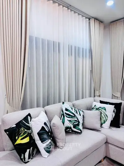 Stylish living room with modern sectional sofa and elegant curtains