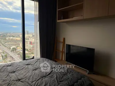 Cozy bedroom with city view, featuring a large window, modern TV, and stylish shelving.