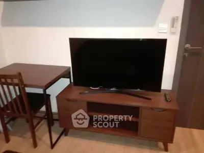 Modern living room with sleek TV stand and compact dining table, perfect for cozy urban living.