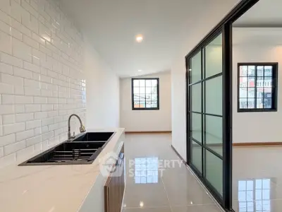Modern kitchen with sleek design and open layout, featuring a stylish sink and bright natural lighting.