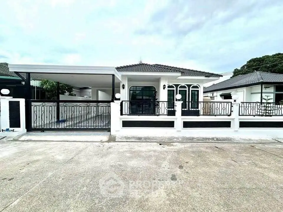 Charming single-story home with elegant wrought iron fence and spacious driveway.