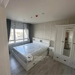 Spacious bedroom with modern furnishings and large window view