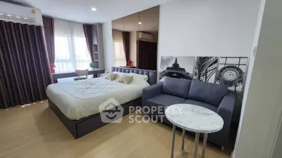 Modern studio apartment with stylish decor and cozy furnishings, featuring a comfortable bed and chic sofa.