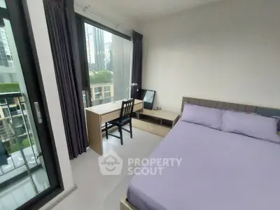 Modern bedroom with city view and workspace in high-rise apartment