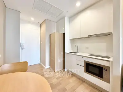 Modern kitchen with sleek cabinets and built-in appliances in a cozy apartment.