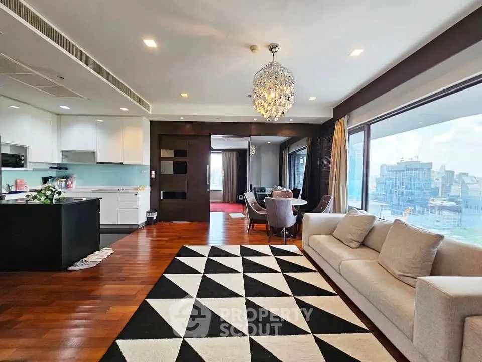 Luxurious open-plan living room with modern kitchen and stunning city view.