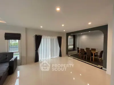 Spacious modern living room with elegant dining area and large windows for natural light.