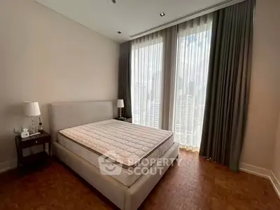 Spacious bedroom with large windows and elegant curtains in a modern apartment