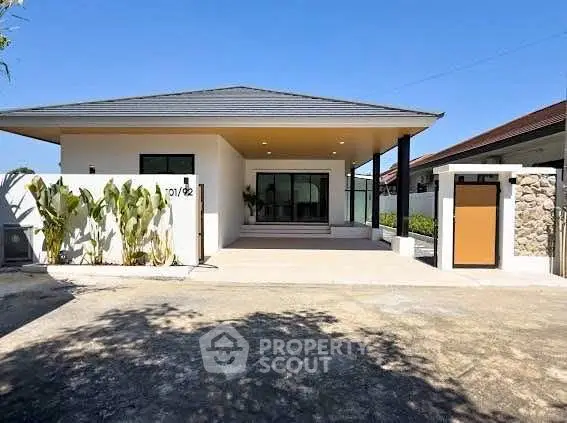 Modern single-story house with sleek design and spacious driveway