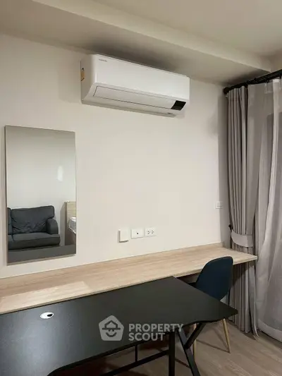 Modern study room with sleek desk, mirror, and air conditioning in a stylish apartment.