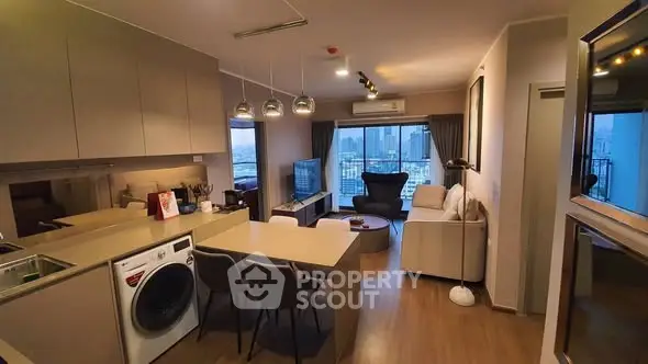 Modern open-plan living room with kitchen, featuring city view and stylish furnishings.