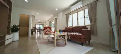 Spacious modern living room with brown leather sofa and large windows