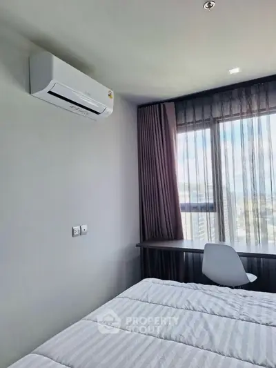 Modern bedroom with air conditioning and city view, featuring a sleek desk and comfortable chair.
