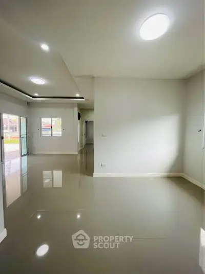 Spacious modern living room with glossy floors and ample natural light