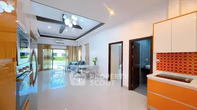 Spacious modern living room with open kitchen and pool view, featuring sleek design and ample natural light.