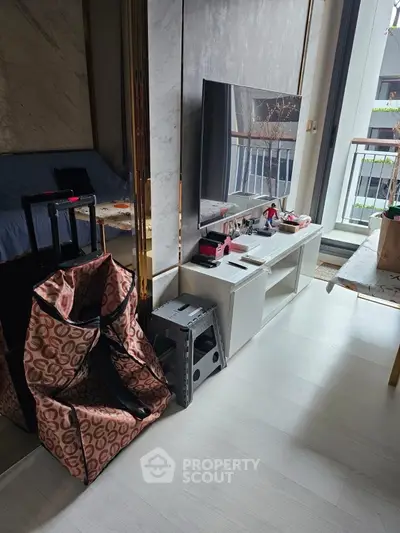 Modern living room with sleek TV setup and balcony view, perfect for urban living.