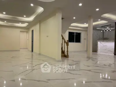 Spacious modern living room with elegant marble flooring and stylish ceiling lights.