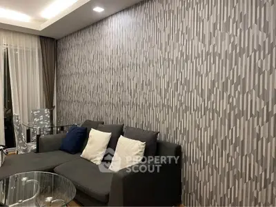 Modern living room with stylish geometric wallpaper and cozy gray sofa
